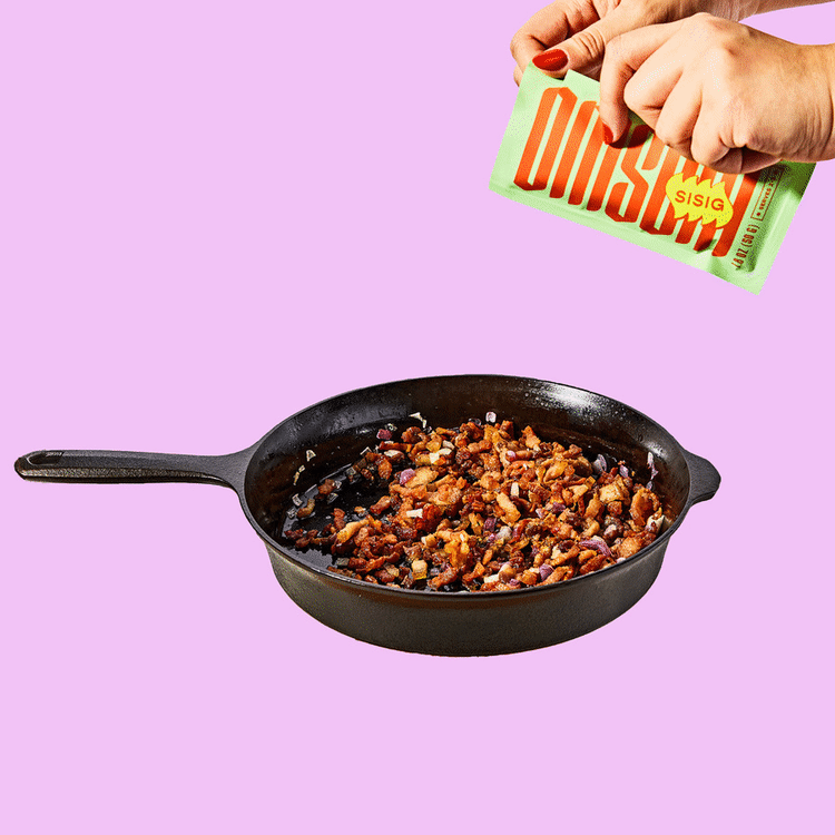 A meal starter packet getting ripped open. Its contents are then added to a cast iron pan full of cooking food. The text reads: Rip, Pour, Fire it up, Enjoy!
