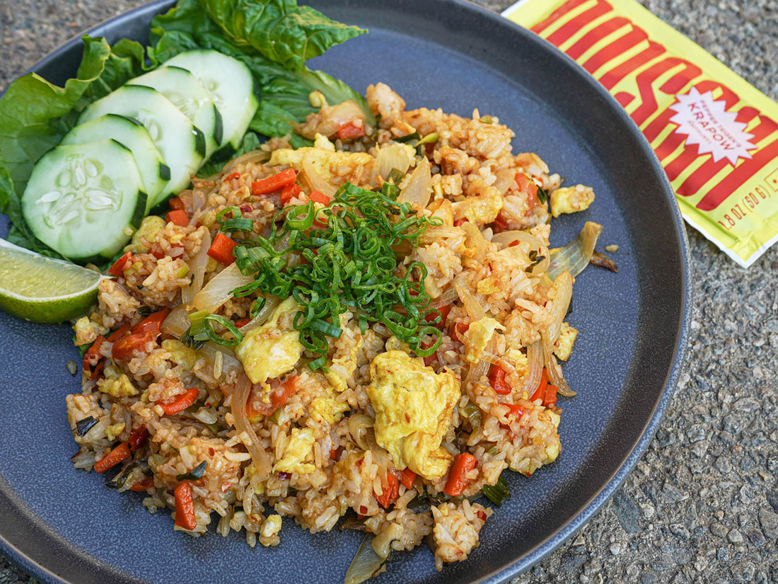 Thai krapow fried rice served on a blue plate. The meal starter packet lies next to the finished dish.