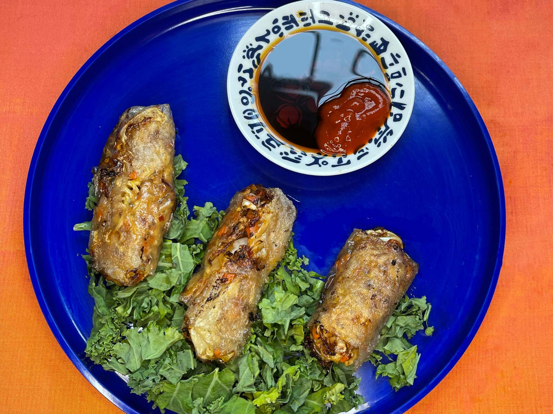 Top-down view of dumplings on a blue plate with a dipping sauce. 