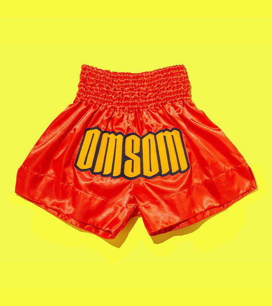 Silky red shorts that say OMSOM across the front
